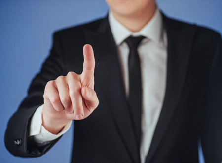 Businessman hand pointing on empty space on black background in the studio