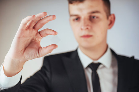 The young businessman in a suit shows his hand on a dark background isolated