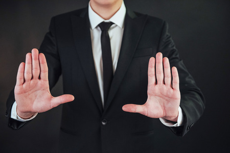 The young businessman in a suit shows his handの写真素材
