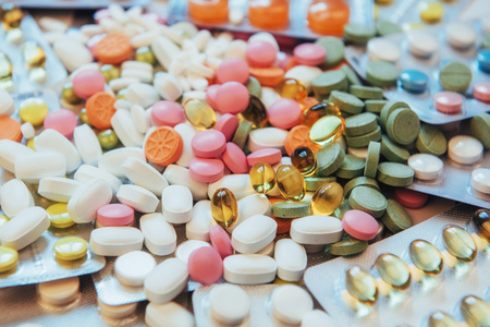 Pills of different colors lie on the surface in a sealed packageの写真素材