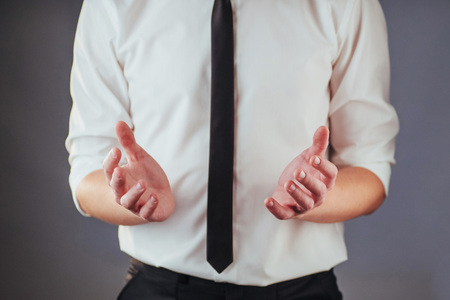 The young businessman in a suit shows his handの写真素材
