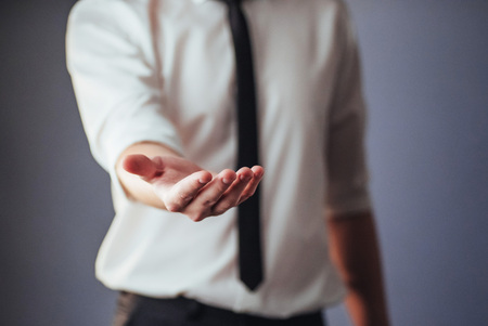 Young businessman showing empty hands, ready to fill with your design.の写真素材