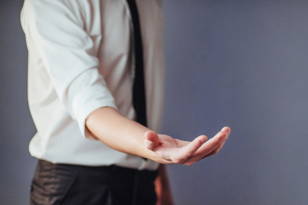 Young businessman showing empty hands, ready to fill with your design.の写真素材