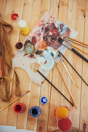 The artist's palette. Colored oil paints over a pallete on a tableの写真素材