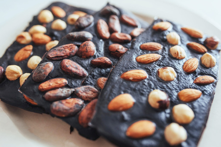 Dark chocolate, isolated on white with whole nuts.の写真素材