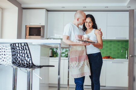 Happy young couple having coffee in the kitchenの写真素材