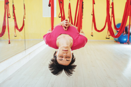 young woman making antigravity yoga exercisesの写真素材