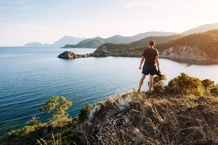 Tourist admiring the blue Mediterranean sea on the Turkish coast in the eveningの写真素材