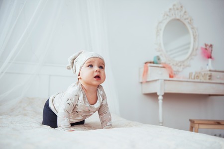 Newborn baby dressed in a suit on a soft bed in the studio.の写真素材