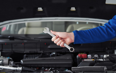 Hands of car mechanic with wrench in garage.の写真素材