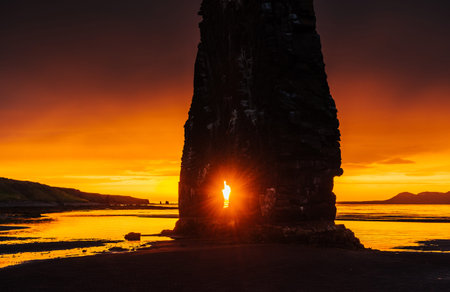 Is a spectacular rock in the sea on the Northern coast of Iceland. Legends say it is a petrified troll. On this photo Hvitserkur reflects in the sea water after the midnight sunsetの写真素材