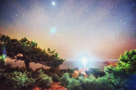 Milky Way above the Lighthouse over the rocky beachの写真素材