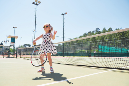 Cute girl playing tennis and posing for the cameraの写真素材