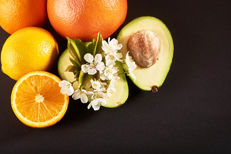 grapefruit, orange and avocado, isolated on a black backgroundの写真素材