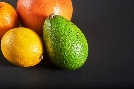 Delicious fresh orange, grapefruit, avocado, lemon isolated on a black background.の写真素材