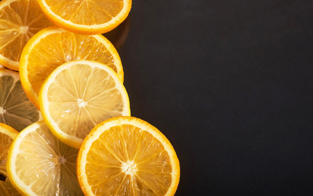 slices of orange and lemon, isolated on a black backgroundの写真素材