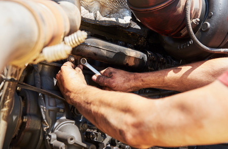 Combine machine service, mechanic repairing motor outdoorsの写真素材