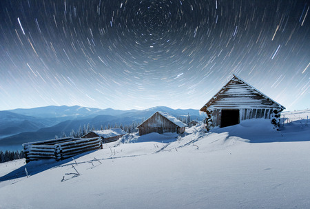 chalets in the mountains at night under the stars. Magic event in frosty day. In anticipation of the holiday. Dramatic scenesの写真素材