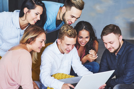 Group of creative young Friends Hanging Social Media Concept. People Together Discussing Creative Project During Work Process, play games or watch video filmの写真素材
