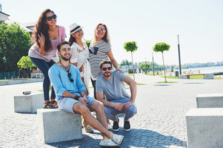 Group of people sitting on a staircase outdoors - Multiracial friends talking and having fun on a meeting outdoors on beachの写真素材