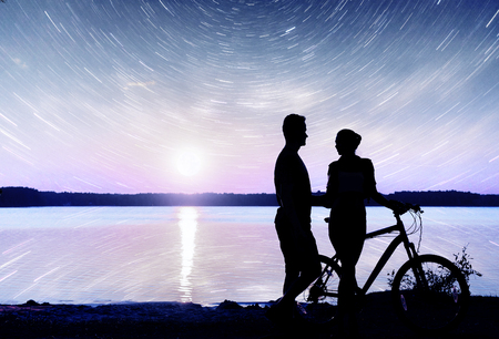 Couple on water background at night sky. Fantastic starry sky and the milky way.の写真素材