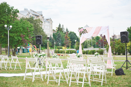 Freshly cut beautiful red and purple wedding flowers garland on chairの写真素材