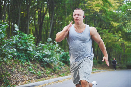Fitness man athlete jogging in the nature during sunset. Person running working out living an active...