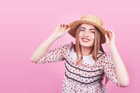 Attractive girl in a white and black stripes, hat, sunglasses, emotionally opened mouth on a bright pink background with a perfect body. Isolated. Studio shot.の写真素材