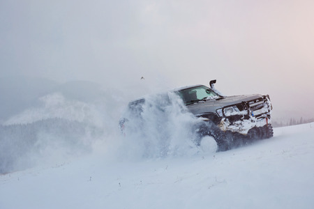 SUV rides on a winter mountians driving risk of snow and ice, drifting.の写真素材