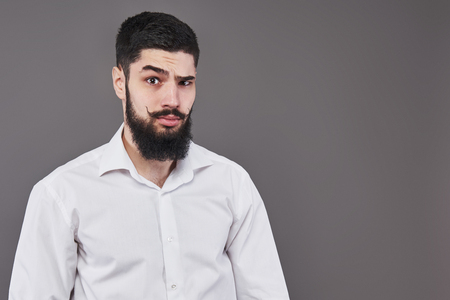Hipster with serious face. Feeling and emotions. Guy or bearded man on grey background. Barber fashion and beauty. Man with long beard and mustache, copy space.の写真素材