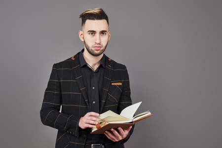Portrait of toothy handsome bearded man with book on hands.の写真素材