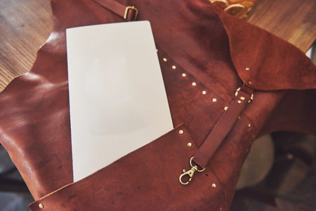Bartender's clothes, bartender apron with leather straps on the table in pub with menu card
