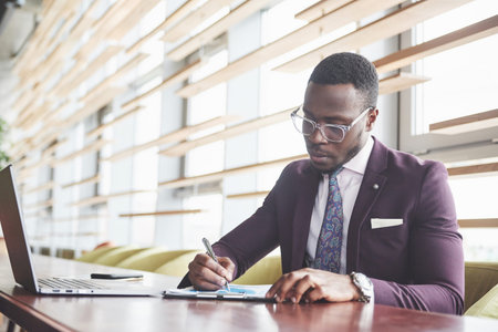 A young businessman signs a contract in a conference room.