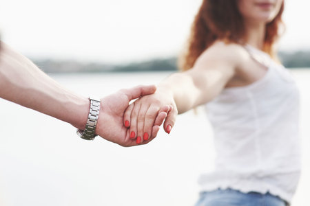 Beautiful girl holding her boyfriends hand. Summer season