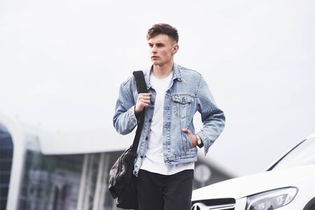 Young boy in a blue denim jacket on the streetの写真素材