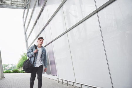 A young beautiful man at the airport is waiting for the flight