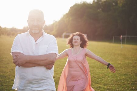 Happy old summer couple smiling at the park on a sunny dayの写真素材