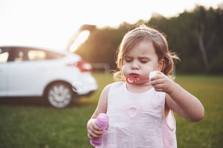 girl blowing bubbles in the park on a summer day.の写真素材