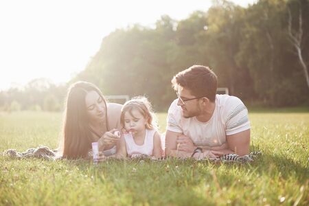 Happy family, father of mother and daughter of baby in the nature at sunset.の写真素材