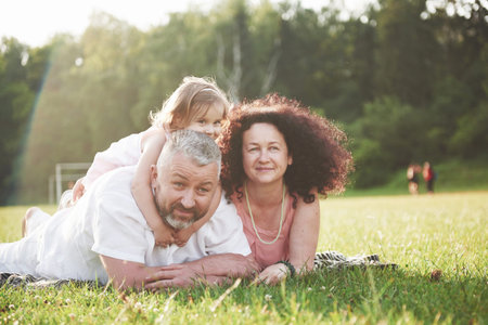 Happy family, father of mother and daughter of baby in the nature at sunset