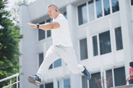 Young sports man doing parkour in the city.の写真素材
