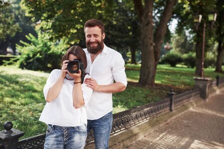 Smiling couple viewing pictures on the camera.の写真素材
