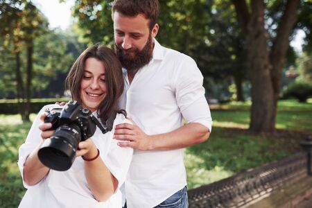 Smiling couple viewing pictures on the camera.の写真素材