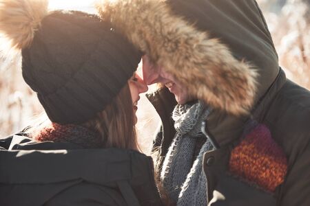 Happy couple playful together during winter holidays vacation outside in snow park.の写真素材