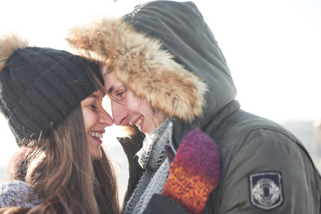 Cheerful young couple having fun in winter park.