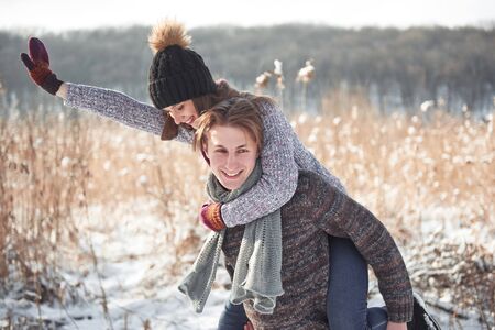 Happy young couple has fun on fresh snow at beautiful winter sunny day on vacation.の写真素材