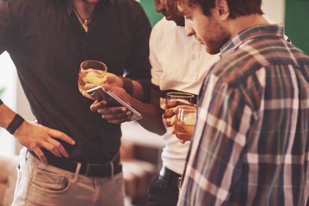 Group of multietnic friends guys with glasses of whiskey. Concept party, bachelor party barbershop.の写真素材