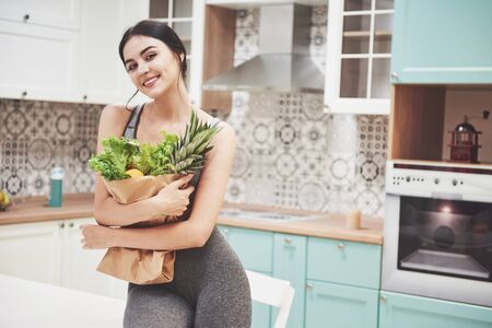 Beautiful woman with healthy food fruit in the kitchenの写真素材