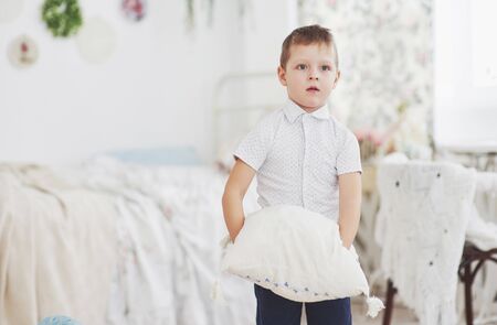 Little boy in white shirt with pillow.の写真素材