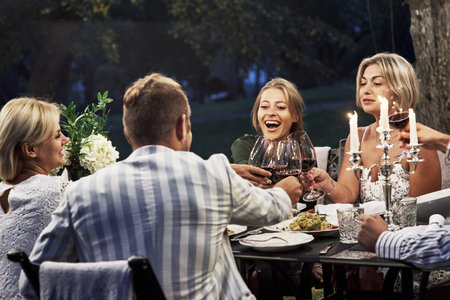 Everyone is happy. Group of adult friends have a rest and conversation in the backyard of restaurant...